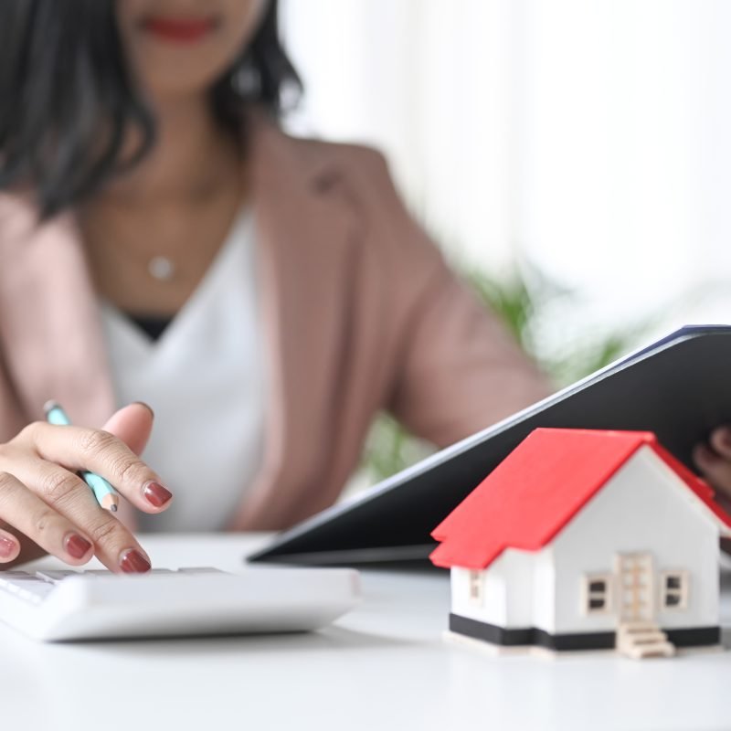 Businesswoman using calculator. Concept of saving money for buy a new house and plan business investment for real estate in the future.