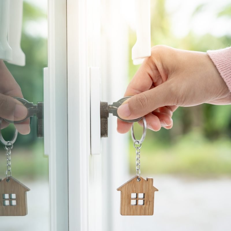 Landlord key for unlocking house is plugged into the door. Second hand house for rent and sale. Owner use hand unlock door mortgage for new home, buy, sell, renovate, investment, owner, estate